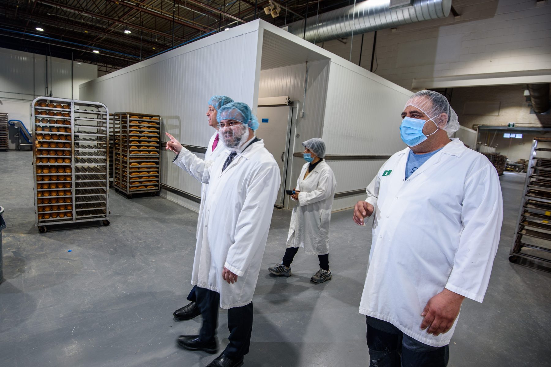 VegeCert inspection team reviewing labeled bakery racks in a production facility
